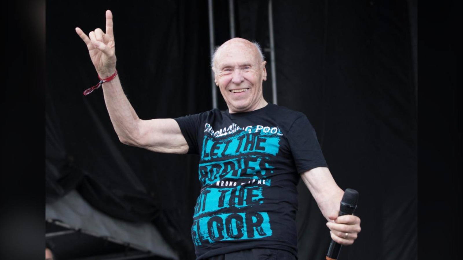 John Hetlinger on stage with a microphone